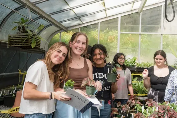 A group of students pick out their first-year plants in the greenhouse.
